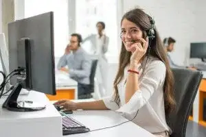 Young friendly operator with headsets working in a call centre.