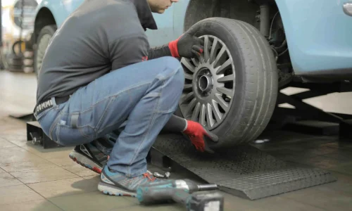 man fixing a tire on his car - dynamic number insertion for automotive industry