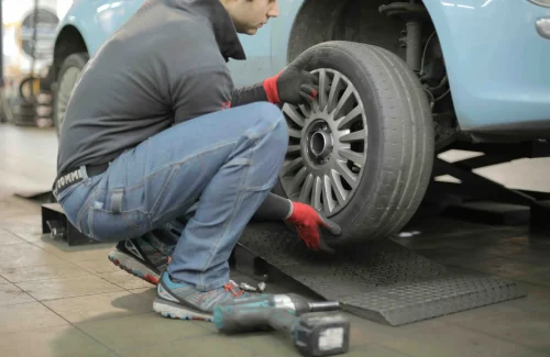 man fixing a tire on his car - dynamic number insertion for automotive industry