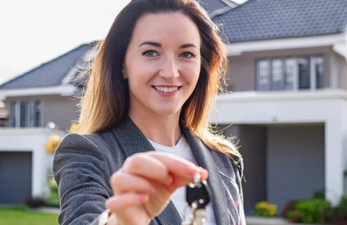 A-real-estate-agent-holding-keys_-handing-them-to-new-home-owners