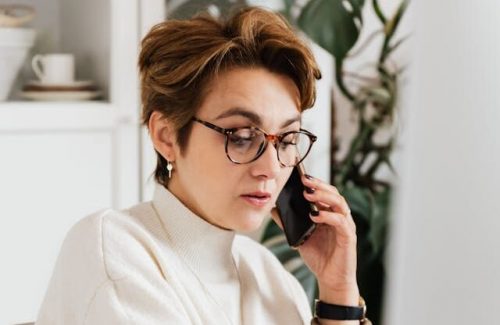 Professional person on the phone looking at laptop.